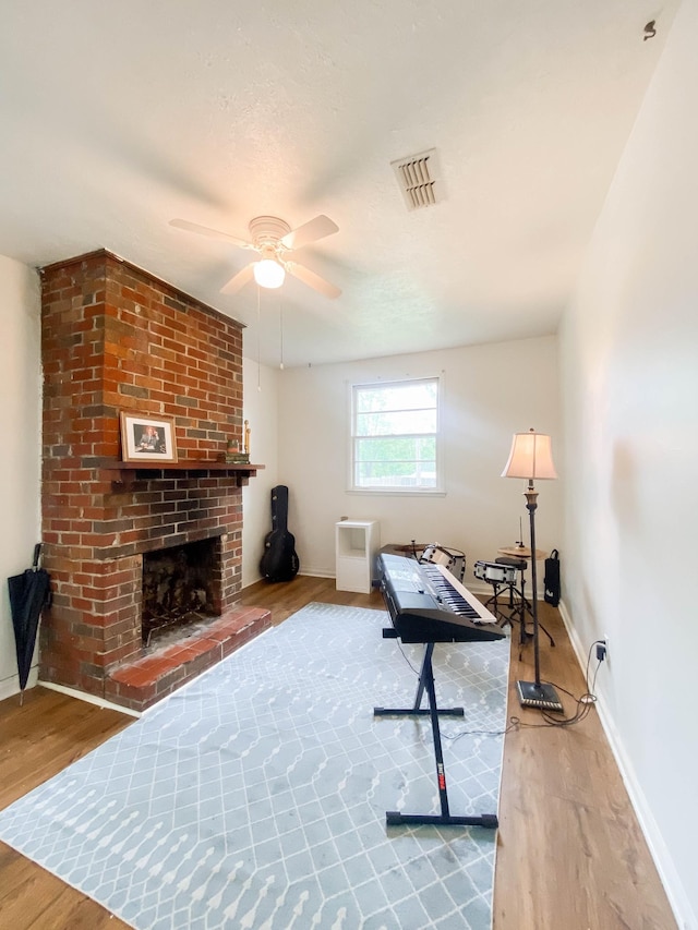interior space featuring a ceiling fan, baseboards, visible vents, and wood finished floors