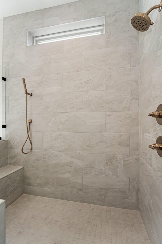 full bath featuring a tile shower and a healthy amount of sunlight