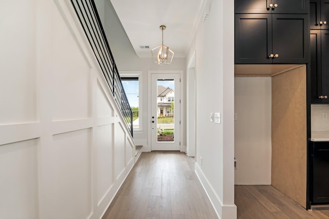 entryway with light wood-style floors, a notable chandelier, and visible vents