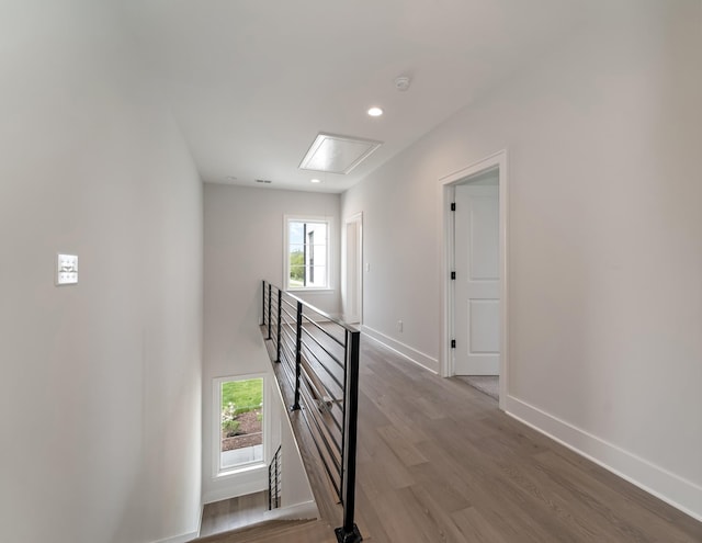 hall featuring plenty of natural light, attic access, wood finished floors, and an upstairs landing