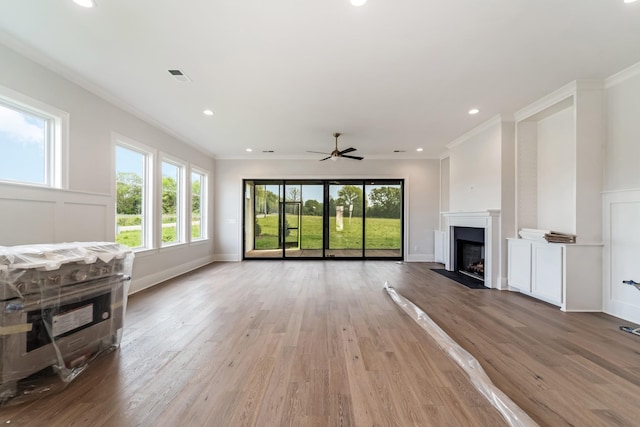 unfurnished living room with visible vents, light wood-type flooring, a healthy amount of sunlight, and a fireplace