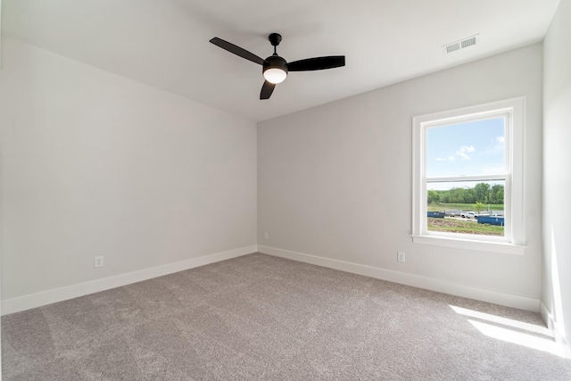 unfurnished room with carpet flooring, ceiling fan, visible vents, and baseboards