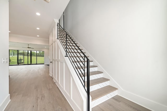 stairway with a ceiling fan, crown molding, wood finished floors, baseboards, and recessed lighting