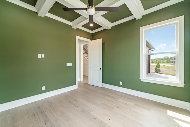 spare room with beamed ceiling, baseboards, ceiling fan, coffered ceiling, and light wood finished floors