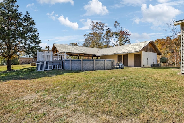 635 Cane Creek Rd, Hohenwald, TN 38462 - rear view of house with a yard, central AC, metal roof, and an outdoor pool