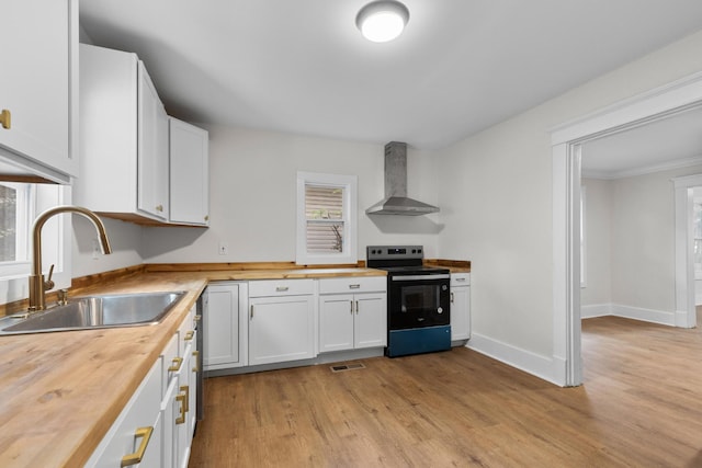 1903 S Orchard Knob Ave, Chattanooga, TN 37404 - kitchen featuring wall chimney range hood, a sink, wooden counters, light wood-style flooring, and black range with electric stovetop