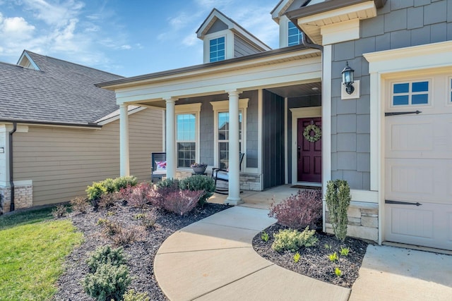 property entrance featuring roof with shingles, a porch, and stone siding