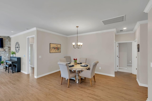 dining room featuring baseboards, ornamental molding, light wood-style flooring, and visible vents