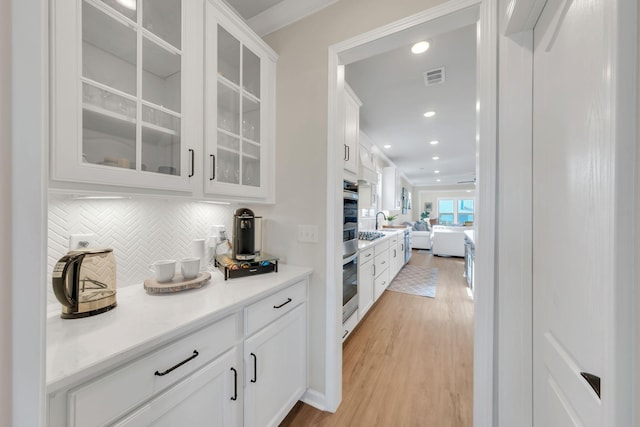 bar with visible vents, ornamental molding, recessed lighting, light wood-style flooring, and backsplash