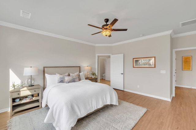 bedroom with crown molding, baseboards, visible vents, and light wood-style flooring