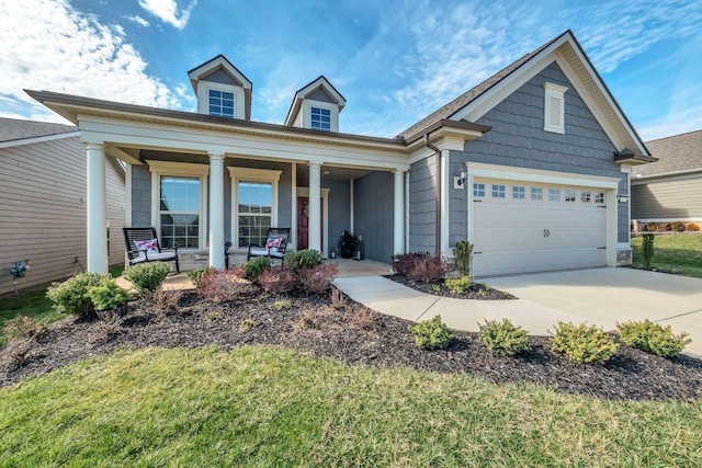 view of front of home with a porch, a garage, driveway, and a front yard