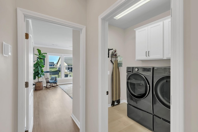 laundry room with separate washer and dryer, cabinet space, crown molding, and baseboards