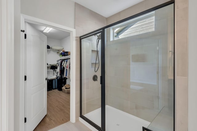full bathroom with a spacious closet and a shower stall