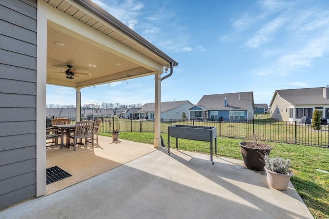 view of patio / terrace featuring a ceiling fan, a residential view, outdoor dining space, and a fenced backyard