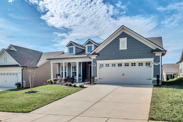 view of front of house with an attached garage, a porch, driveway, and a front yard
