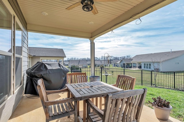 view of patio with a residential view, fence, area for grilling, outdoor dining area, and a ceiling fan