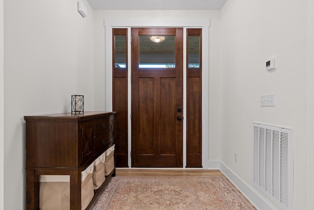 foyer featuring baseboards, visible vents, and light wood finished floors