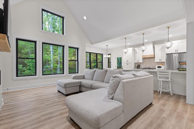living room with recessed lighting, light wood finished floors, and high vaulted ceiling
