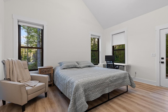 bedroom featuring high vaulted ceiling, baseboards, and wood finished floors