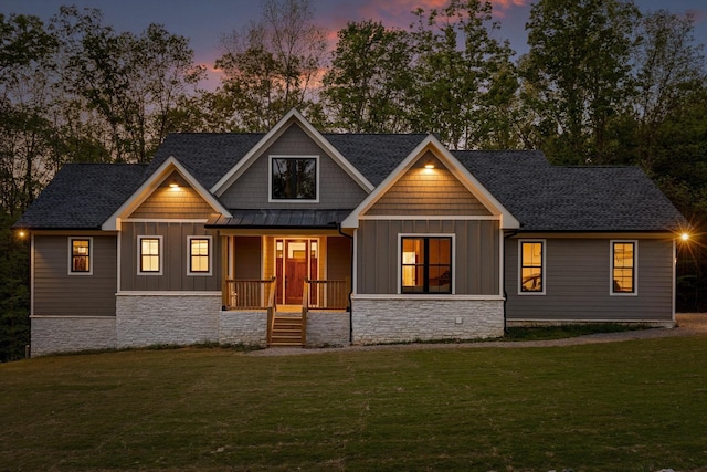 craftsman-style home featuring board and batten siding, a yard, a porch, and stone siding