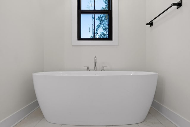 bathroom with baseboards and a freestanding bath