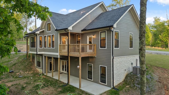 rear view of house with roof with shingles, central AC unit, a patio area, brick siding, and a yard
