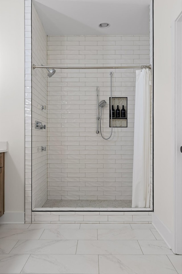 full bathroom featuring vanity, baseboards, a shower stall, and marble finish floor