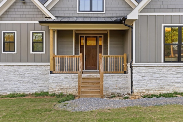 property entrance featuring board and batten siding, a standing seam roof, and stone siding