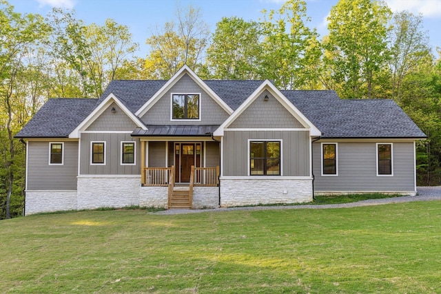 craftsman-style home with a porch, board and batten siding, a front yard, and stone siding