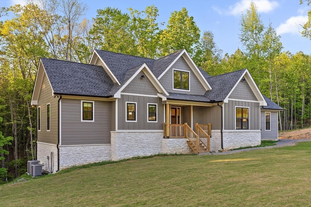 view of front of home featuring board and batten siding, a front yard, and stone siding