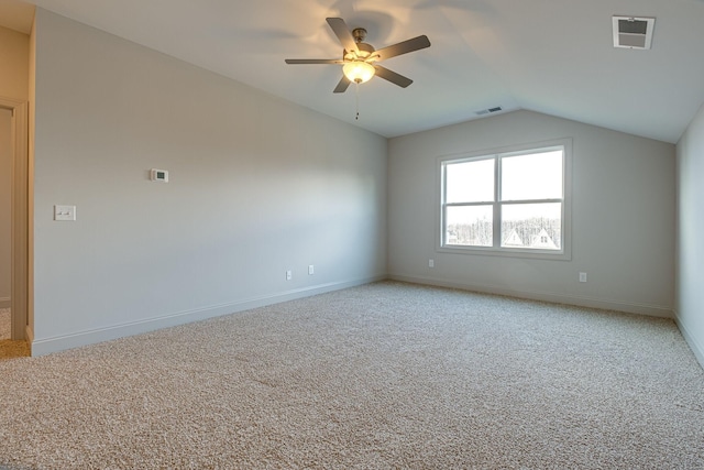 unfurnished room with visible vents, ceiling fan, lofted ceiling, and light carpet