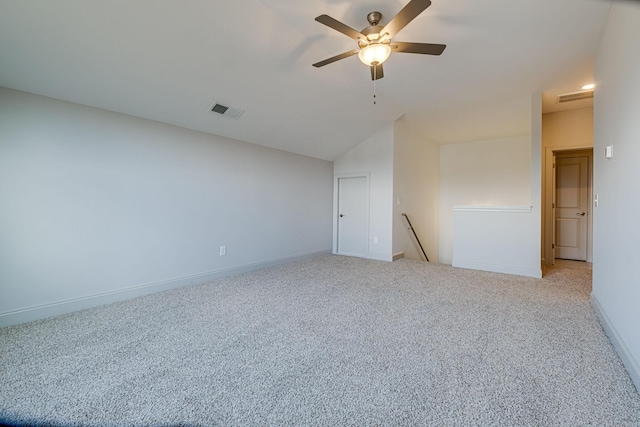 spare room featuring carpet flooring, ceiling fan, baseboards, lofted ceiling, and visible vents