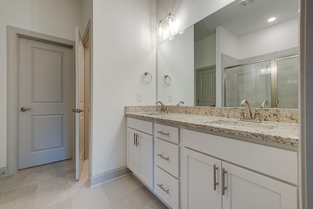full bathroom featuring baseboards, a sink, double vanity, and a shower stall
