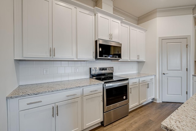 kitchen featuring light stone countertops, white cabinetry, tasteful backsplash, dark wood finished floors, and stainless steel appliances