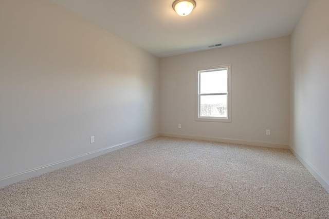unfurnished room with baseboards, light colored carpet, and visible vents
