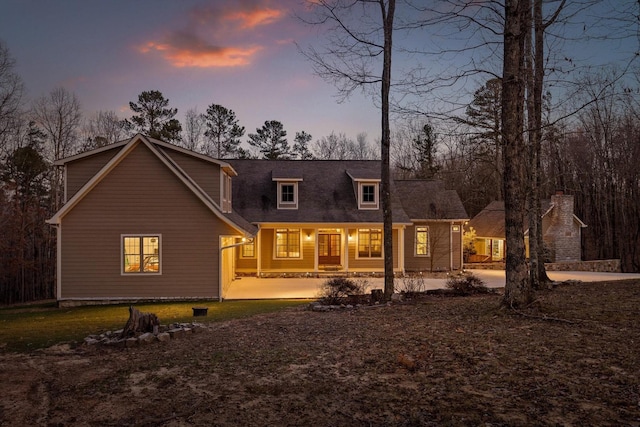 back of property at dusk with a porch