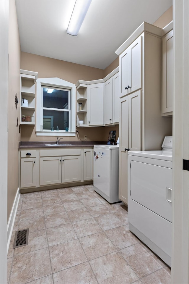 laundry area with independent washer and dryer, visible vents, cabinet space, a sink, and light tile patterned floors