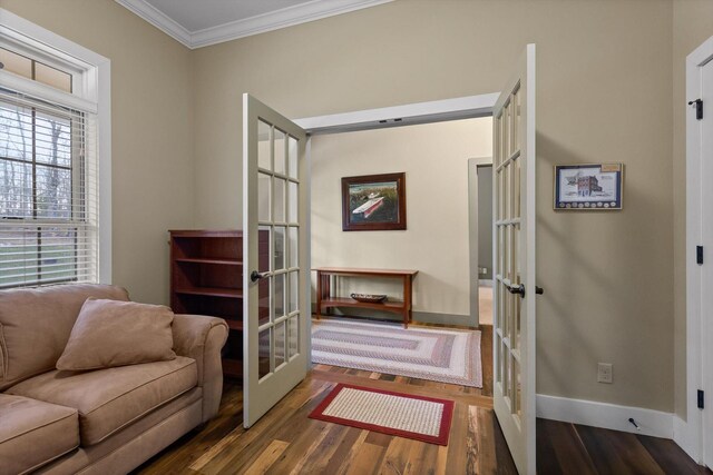 sitting room featuring french doors, ornamental molding, baseboards, and wood finished floors