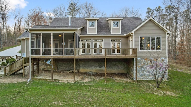 back of house featuring roof with shingles, a lawn, a deck, a sunroom, and stairs