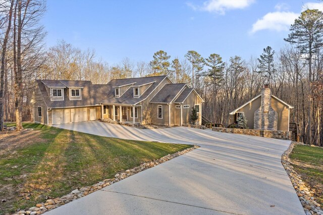 view of front facade featuring a garage, a porch, driveway, and a front lawn