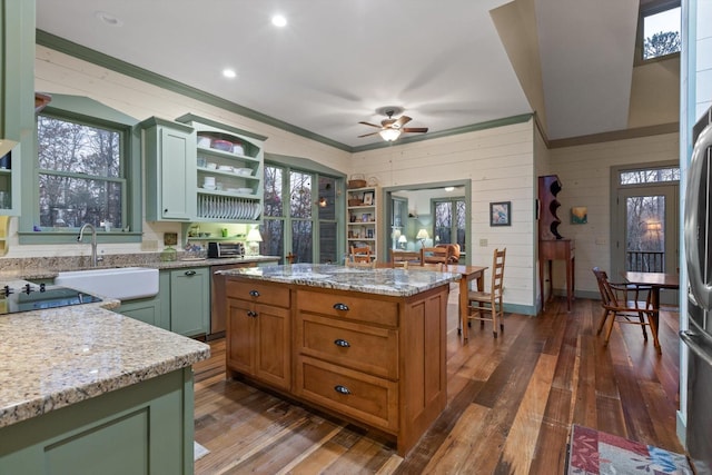 kitchen featuring ceiling fan, open shelves, a sink, wood walls, and dark wood-style floors