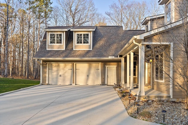 view of front of property featuring a shingled roof and concrete driveway