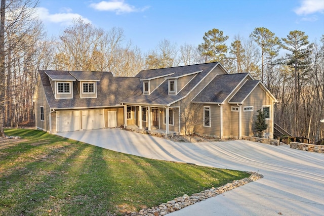 view of front of property featuring a shingled roof, an attached garage, a front lawn, a porch, and driveway