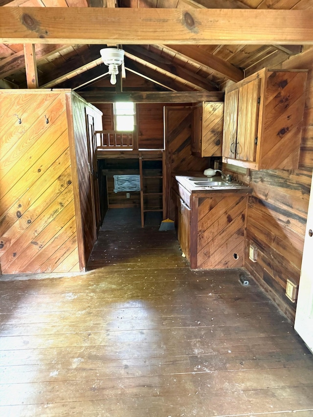 interior space featuring wood walls, dark wood finished floors, and lofted ceiling with beams