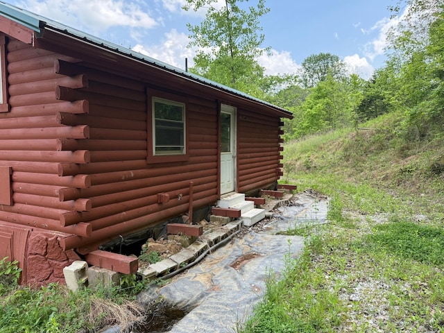 view of property exterior with log exterior and entry steps