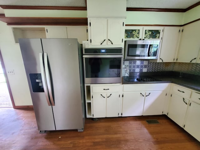 188 Bradford Hill Rd N, Brush Creek, TN 38547 - kitchen featuring dark wood-type flooring, decorative backsplash, dark countertops, and stainless steel appliances