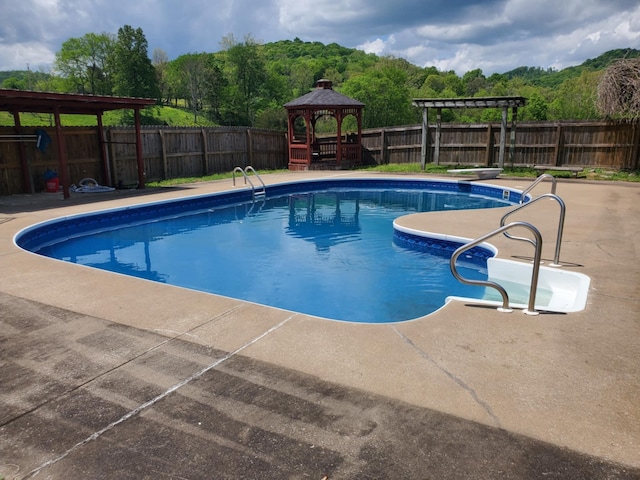 188 Bradford Hill Rd N, Brush Creek, TN 38547 - view of swimming pool with a patio, a fenced backyard, a fenced in pool, a gazebo, and a diving board