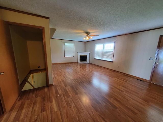 188 Bradford Hill Rd N, Brush Creek, TN 38547 - unfurnished living room with a textured ceiling, ceiling fan, wood finished floors, and a fireplace