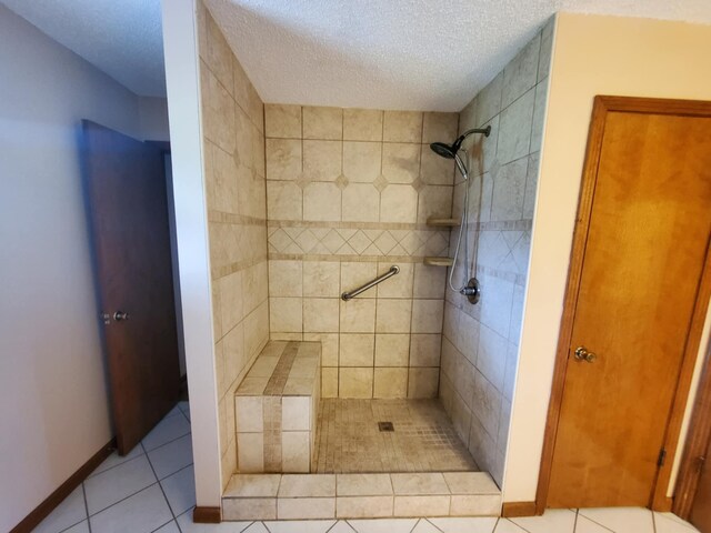 188 Bradford Hill Rd N, Brush Creek, TN 38547 - bathroom with tile patterned flooring, a textured ceiling, baseboards, and a tile shower