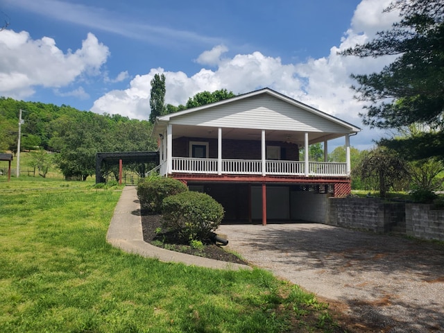 188 Bradford Hill Rd N, Brush Creek, TN 38547 - view of front facade with a wooden deck, a carport, a front yard, and aphalt driveway